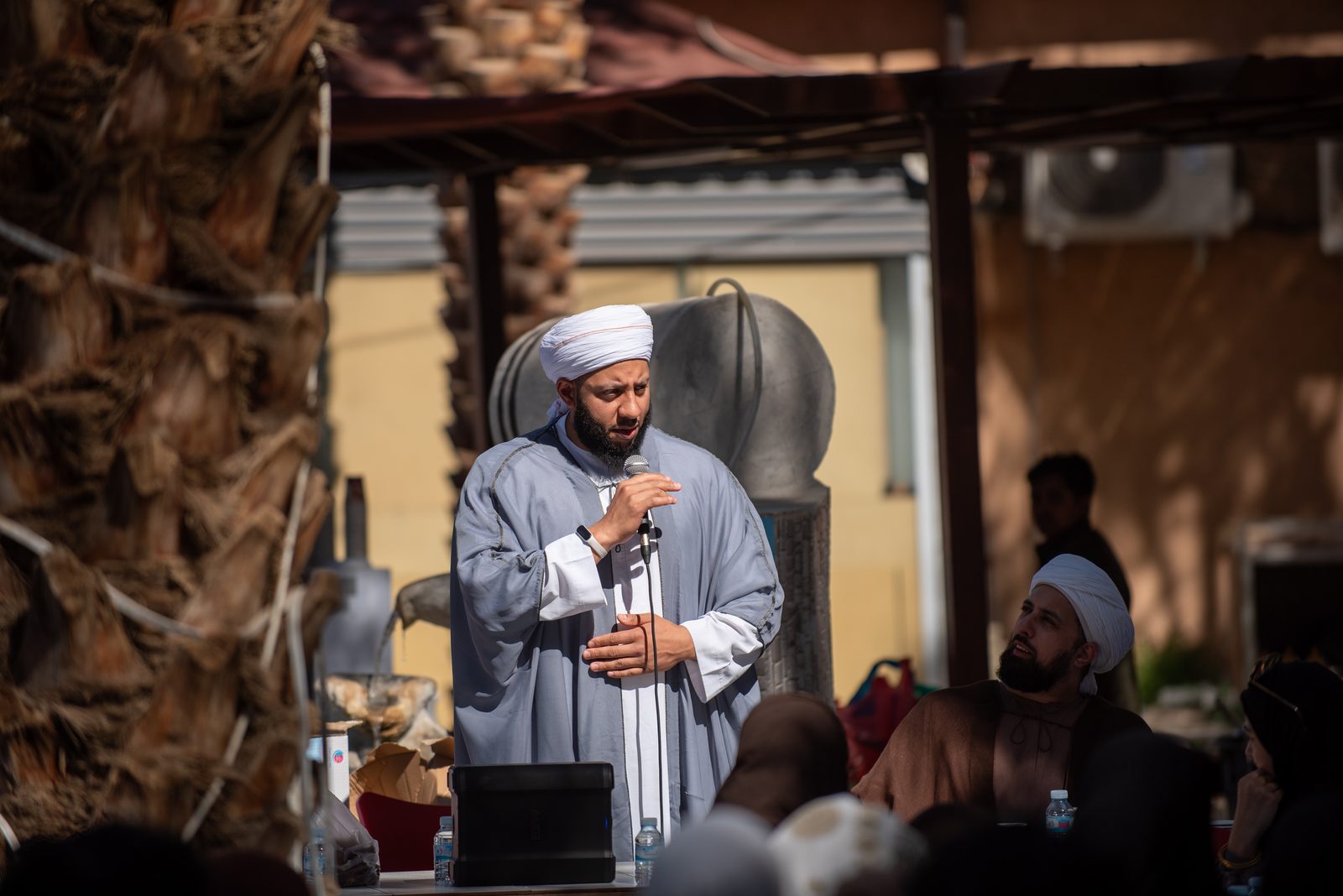 A guide addressing the group under palm trees